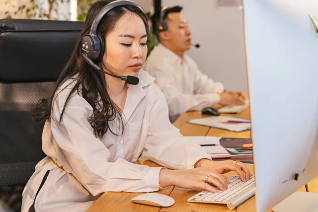 Call center professionals focused on tasks with headsets in a modern office setting. Measuring whether a support technology change reduced customer effort